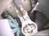 A dark-haired woman in a white blouse and black skirt comes into the stall and sits down, then a camera under the toilet looks up as she goes, with a small inset showing her from the front. Over 5 minutes.
